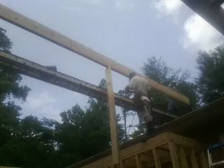 Carpenter setting a ridge beam over a new addition frame — Ice Dam Removal by Roofing Brothers in Yorkville
