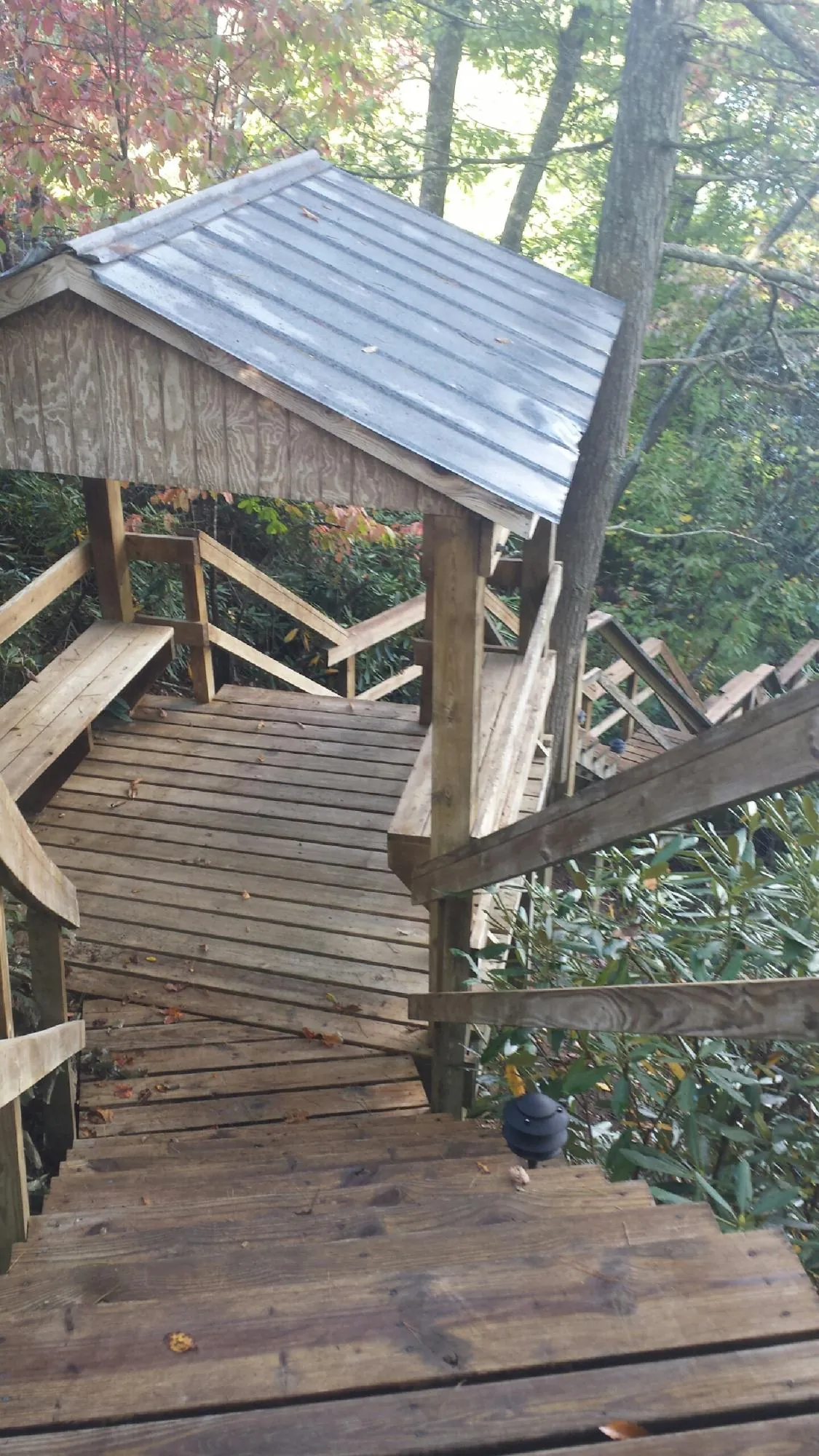 Metal roofed shelter over wooden steps on a wooded walkway — Skylight Repair & Installation work by our crew in Yorkville