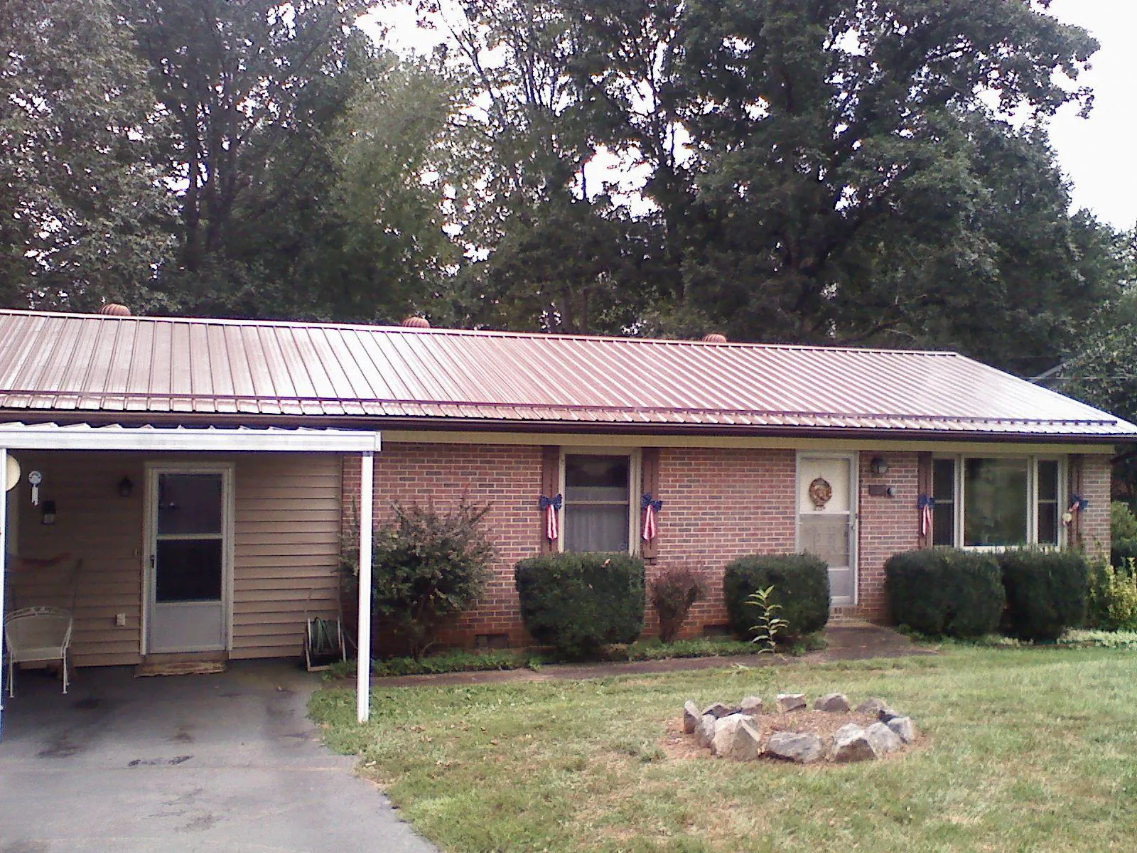 Bronze metal roof and carport on a brick ranch home — Roof Repair work by our crew in Yorkville
